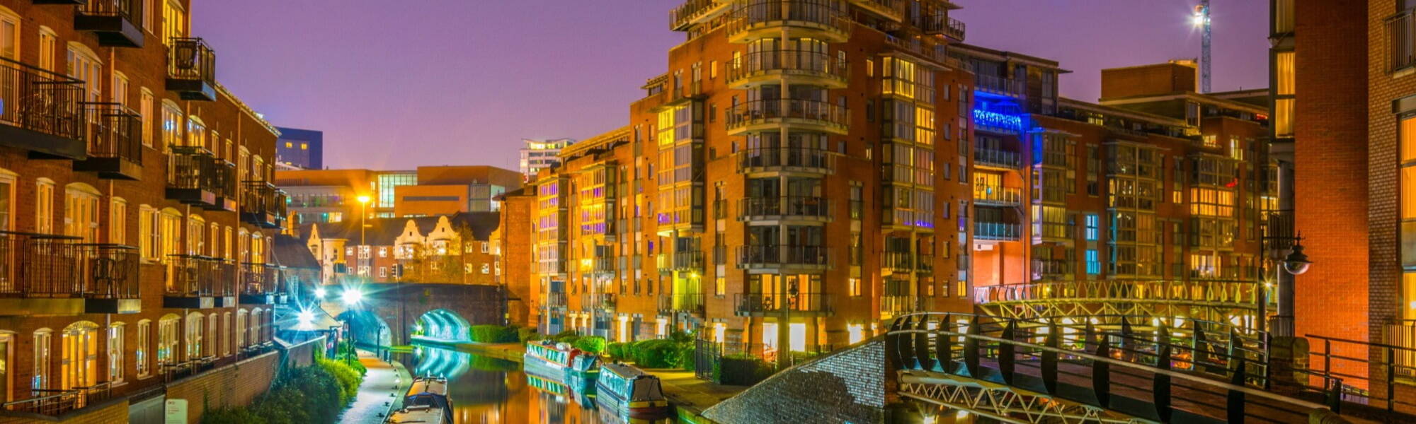 Night view of brick buildings alongside a water channel in the central Birmingham, England