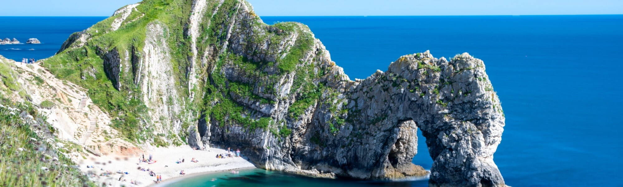 Sunny Dorset coastline with famous landmark Durdle Door
