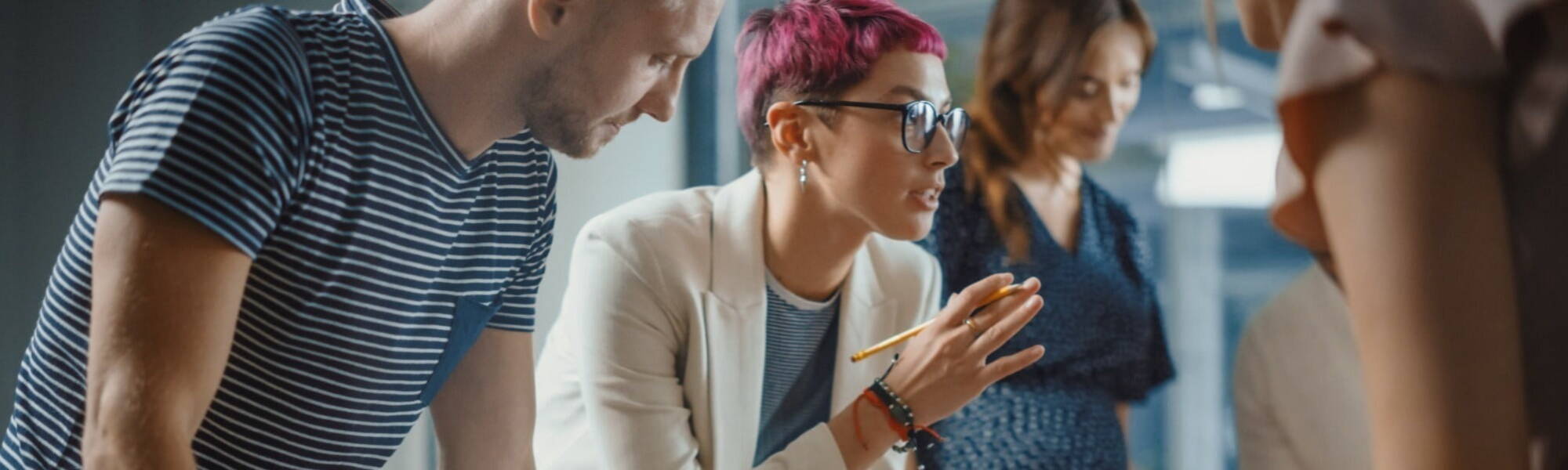 young people engaging in an office meeting set in a modern office